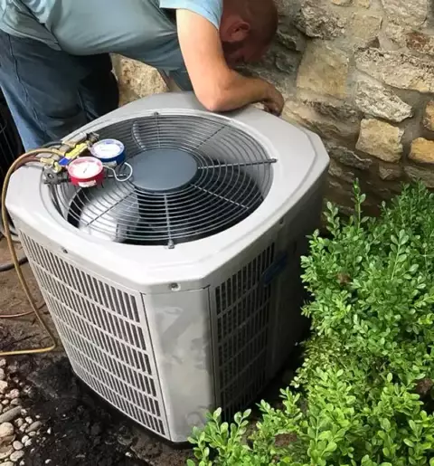 A technician from Nichols & Sons HVAC works to diagnose a customer's air conditioner problem in Tulsa