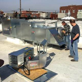 Skilled crew members working on a commercial HVAC unit for a customer